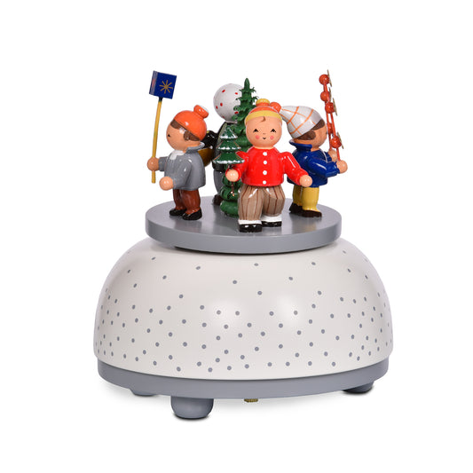Original KWO Spieldose Winterkinder 13007 aus Holz mit handbemalten Figuren und Weihnachtsbaum auf grau-weiß gepunktetem Sockel.