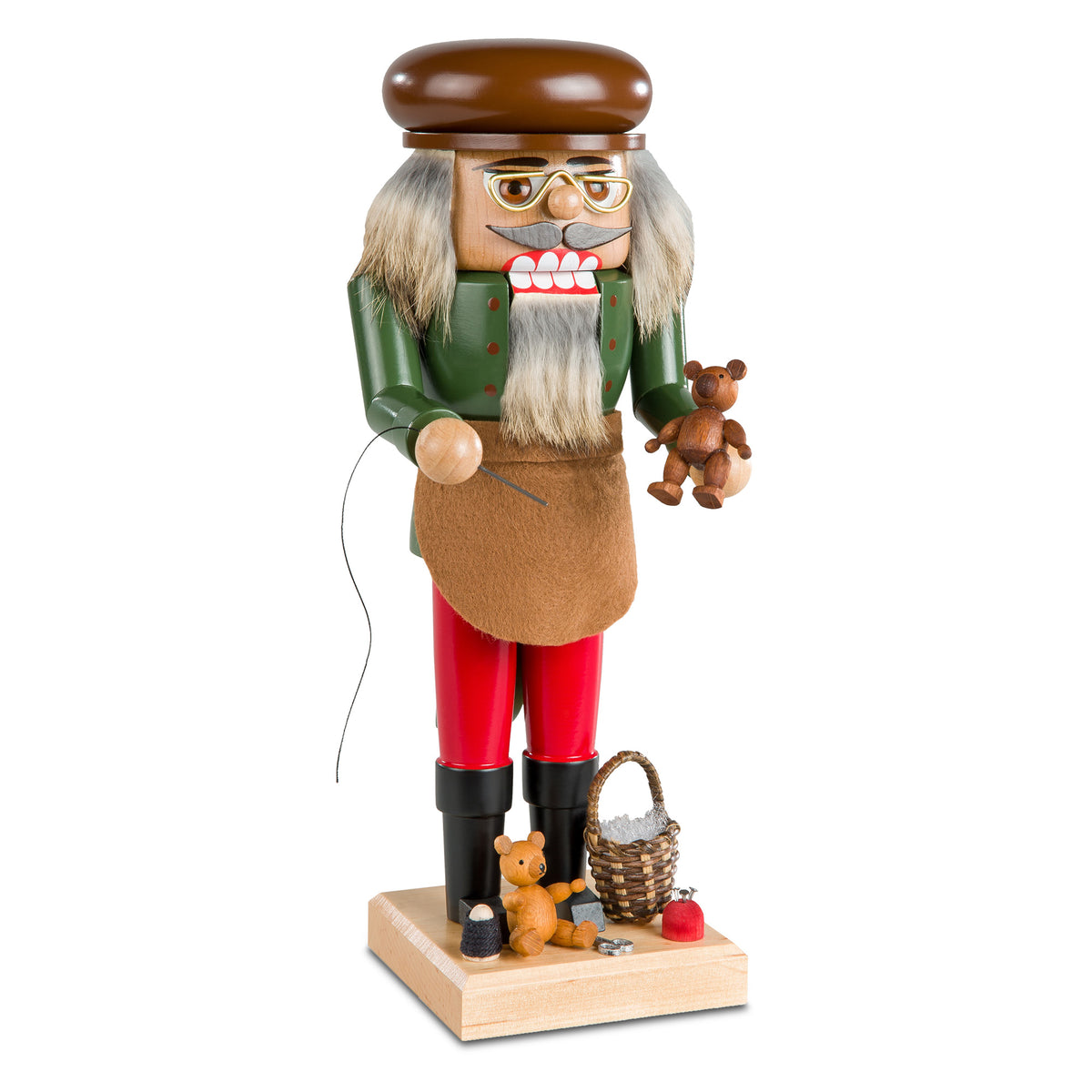 Traditioneller Nussknacker als Spielzeugmacher mit braunem Barett und Schürze, nostalgische Dekoration aus dem Erzgebirge.