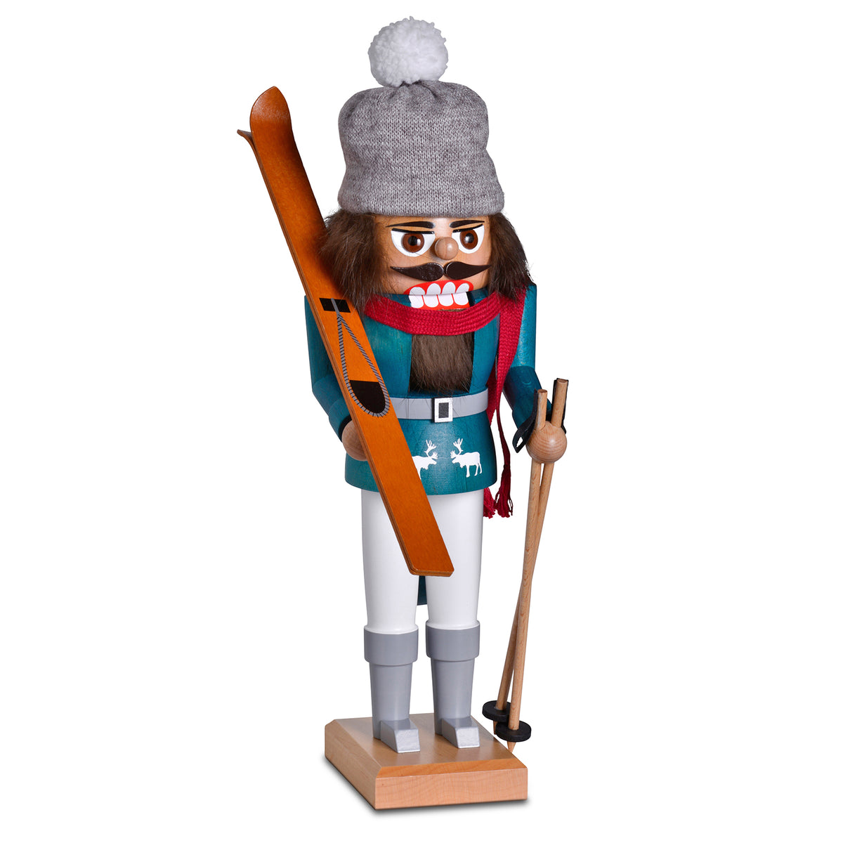 Handgefertigter KWO Nussknacker Skifahrer aus dem Erzgebirge. Die Holzfigur trägt eine graue Strickmütze mit weißem Bommel, einen roten Schal und hält nostalgische Holzski sowie Skistöcke. 29 cm groß.