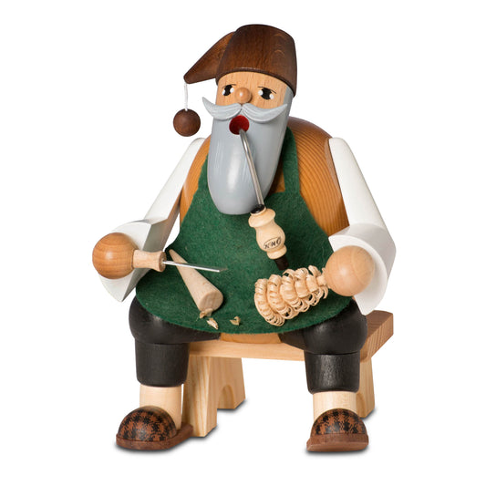 Sitzendes KWO Räuchermännchen Spanbäumchenstecher mit Pfeife, Schnitzmesser und grünem Schurz, inklusive Miniatur-Holzbank.