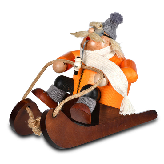KWO Räuchermann Rodel-Andi aus der Serie Die Dicken (Art. 21415), originale Erzgebirge Volkskunst aus Holz auf einem Schlitten mit Pfeife, Schal und Mütze.